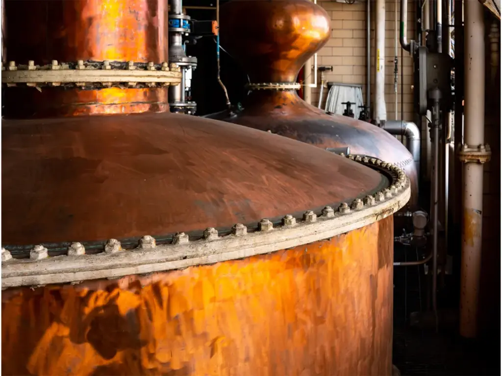 A closeup image of two copper pot stills at the Hiram Walker Distillery, home of J.P. Wiser's